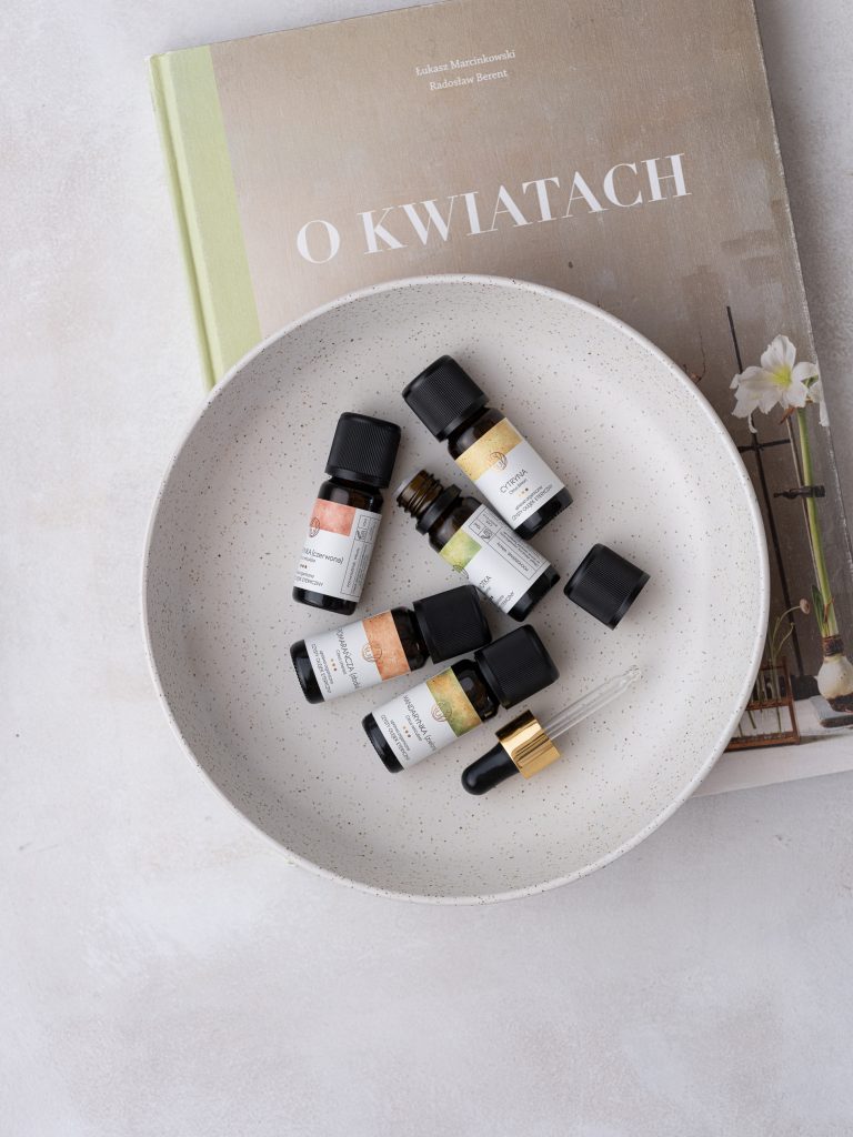 o kwiatach książka, a na nie olejki naturalne na tależu razem z pipetą