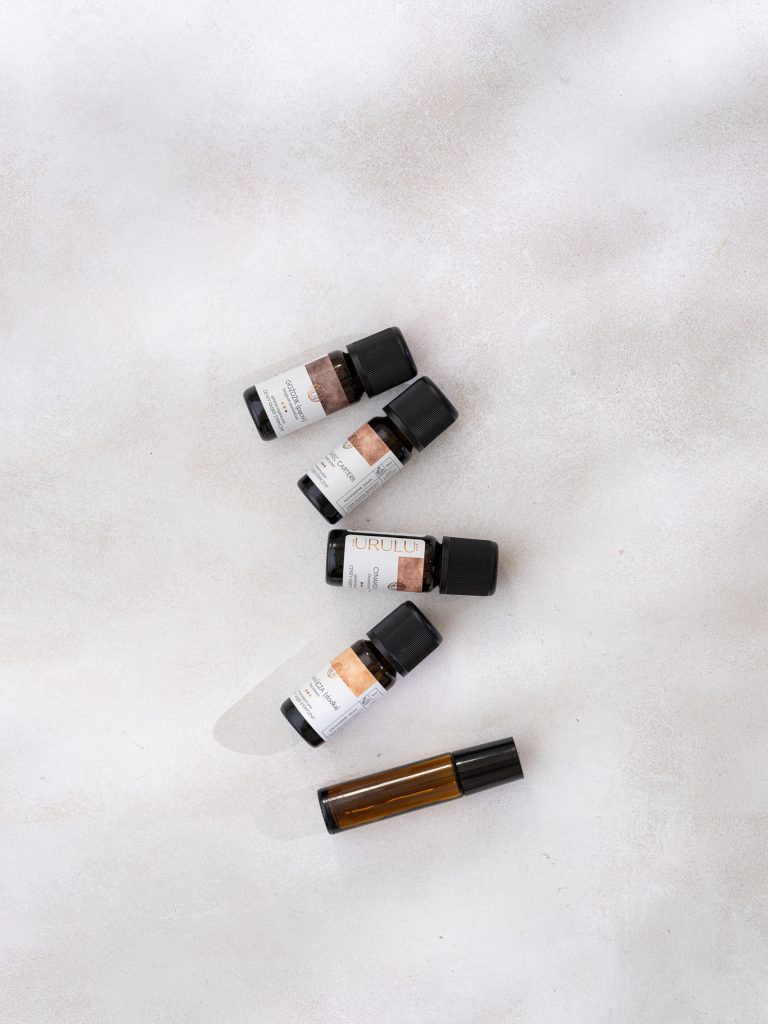 olejki eteryczne i butelka rollon na jasnym tle - fotografia produktowa