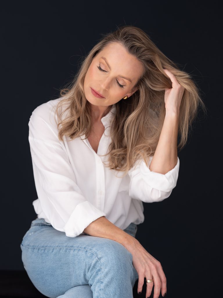 kobieta z zamkniętymi oczami bawiąca się włosami