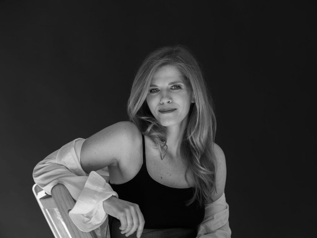 portret pewniej siebie kobiety w body i białej koszuli