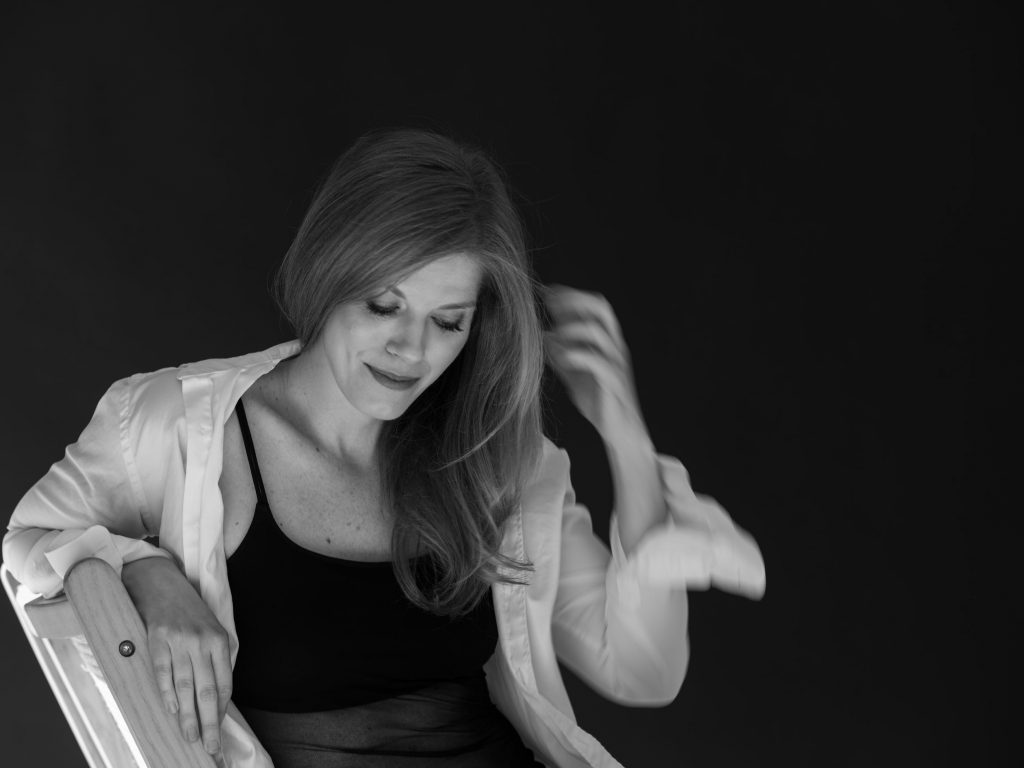 kobieta patrzy w dół i poprawia włosy, sesja kobieca