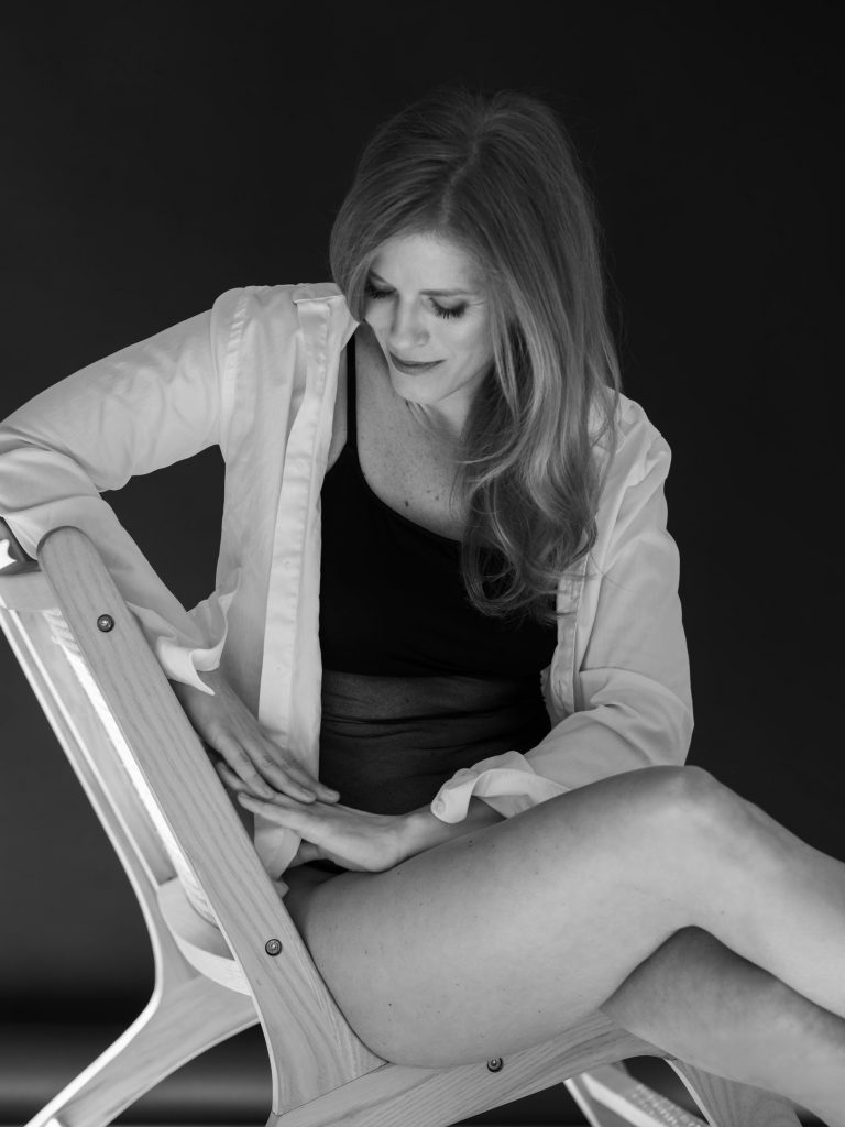 kobieta w czarnym body i białej koszuli siedzi na krześle, kobieca poza, kobieca sesja