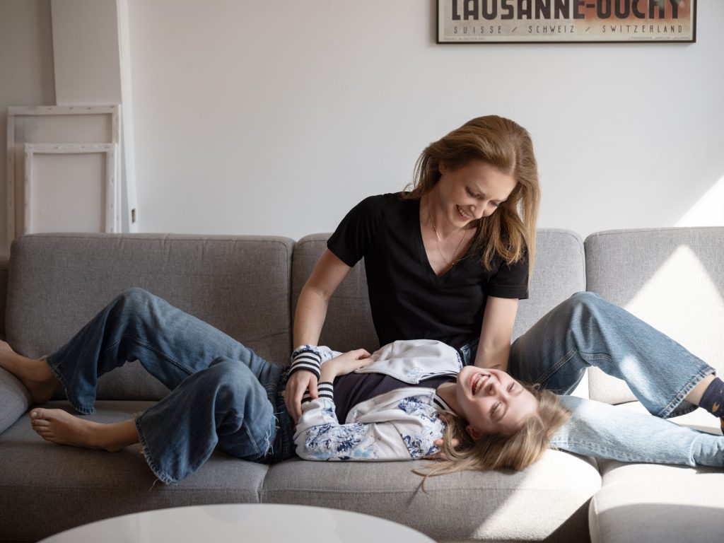 naturalny portret, mama łaskocze córkę, domowa sesja zdjęciowa